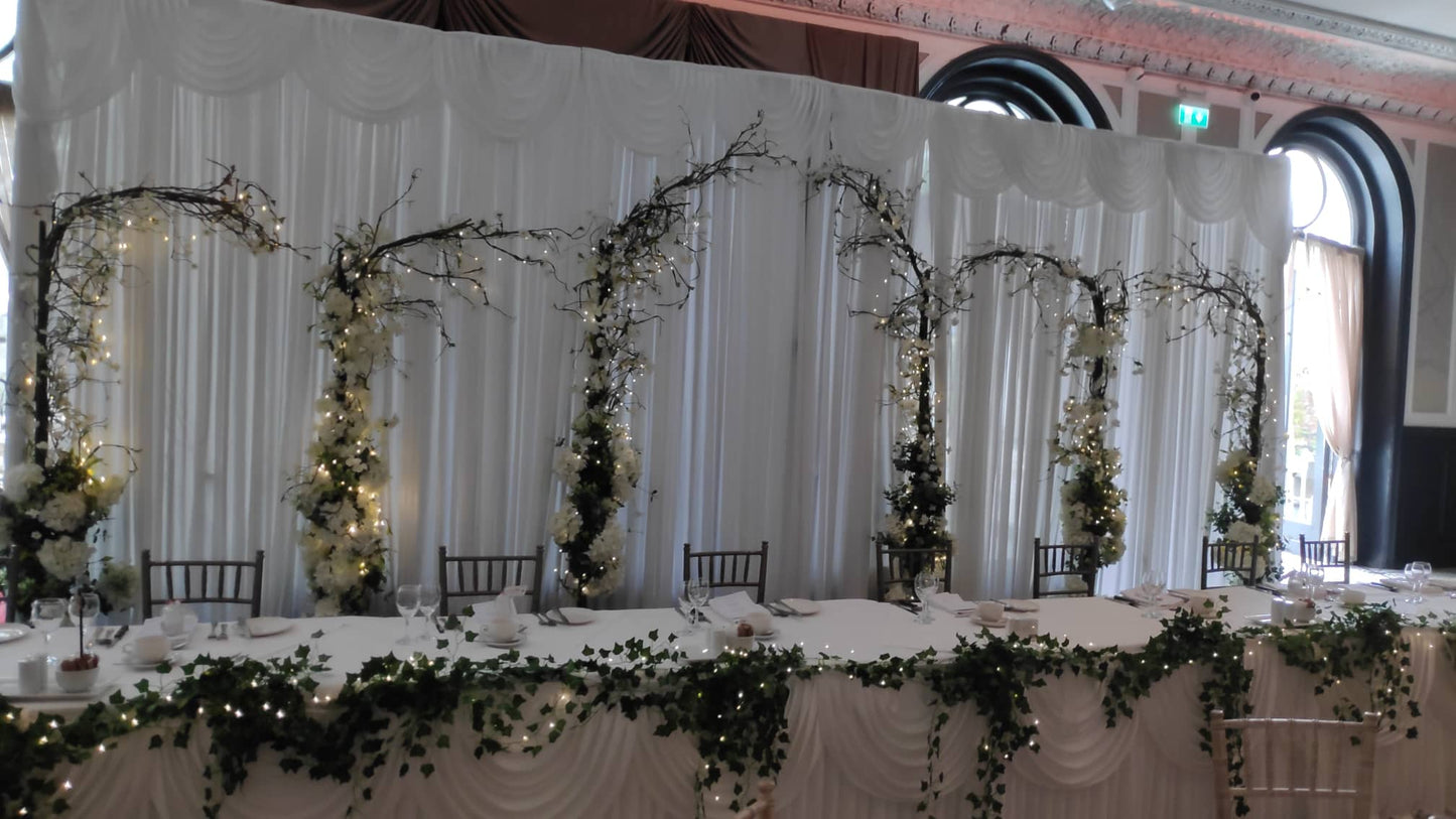Backdrop and light up arches and light up top table greenery